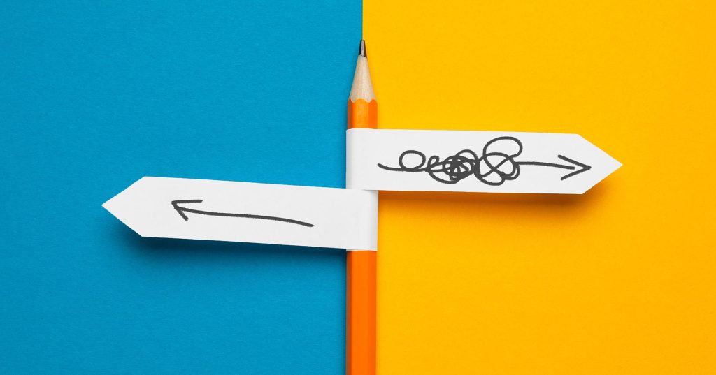 Kynään on kiinnitetty kaksi suuntaviittaa, joista toisessa on suheröä ja nuoli oikealle, toisessa selkeä nuoli vasemmalle.