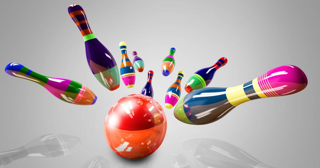 Keilapallo on juuri osunut keiloihin, ja värikkäät keilat lentävät ilmassa.
