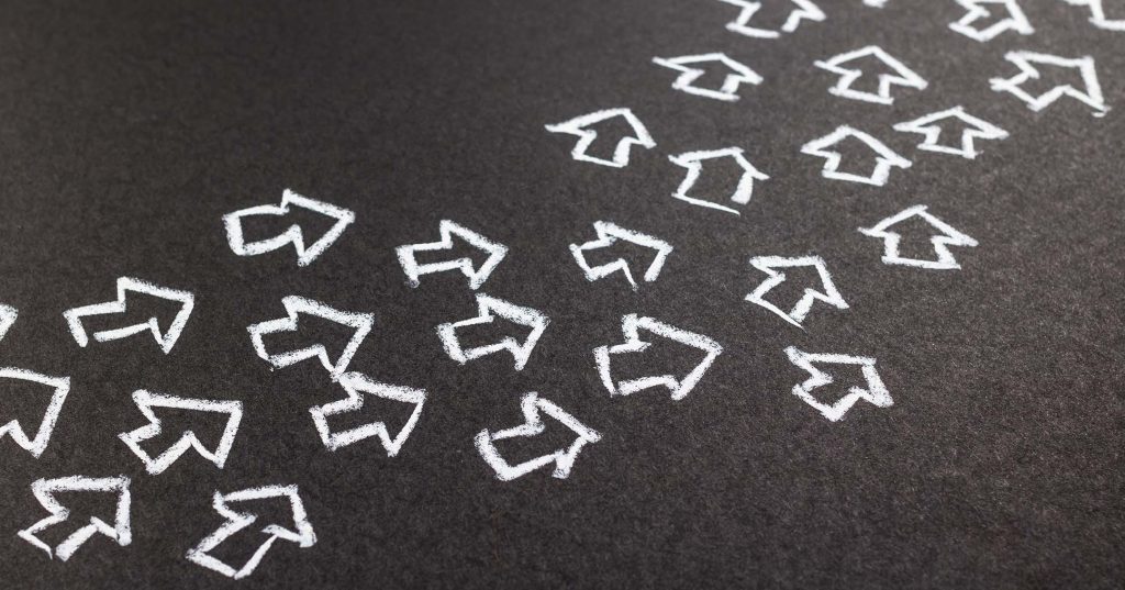 Harmaalle alustalle on piirretty liidulla joukko nuolia, jotka kiemurtelevat samaan suuntaan.