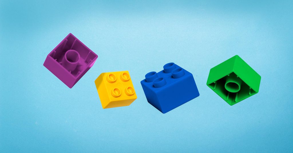 Neljä eriväristä legopalaa leijailee ilmassa.
